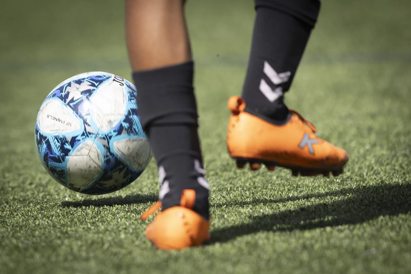 Las botas de un jugador junto al balón, sobre el césped