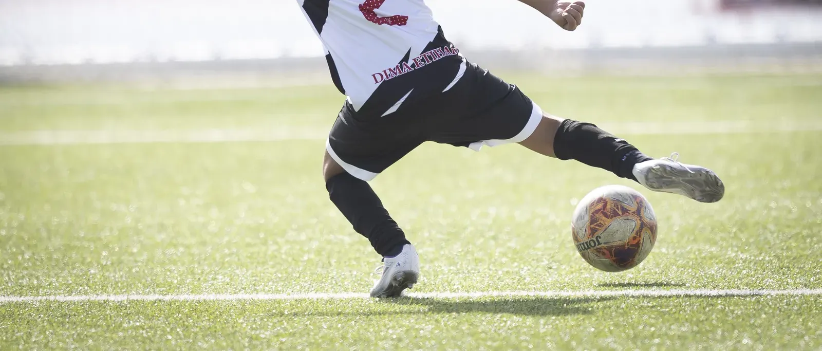 Un jugador golpea el balón con el empeine