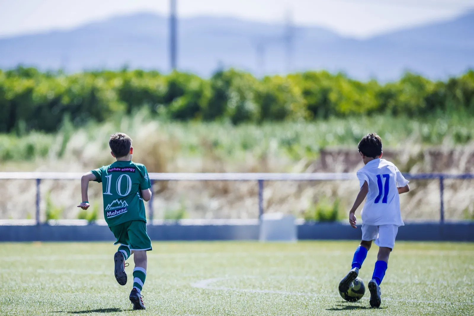 Dos jugadores, de espaldas, con la montaña al fondo